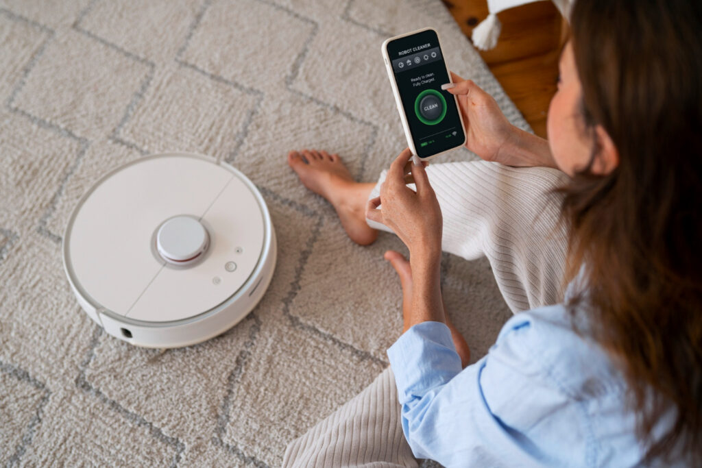 Home Tech Productivity - High angle woman with robotic vacuum cleaner