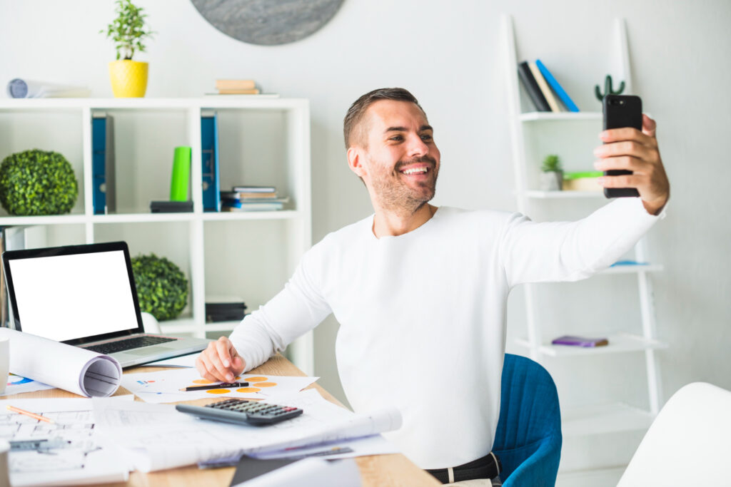 Home Tech Productivity - Portrait of a happy businessman taking selfie from mobile phone
